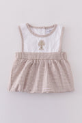 Adorable bubble romper with intricate cross embroidery, perfect for special occasions.