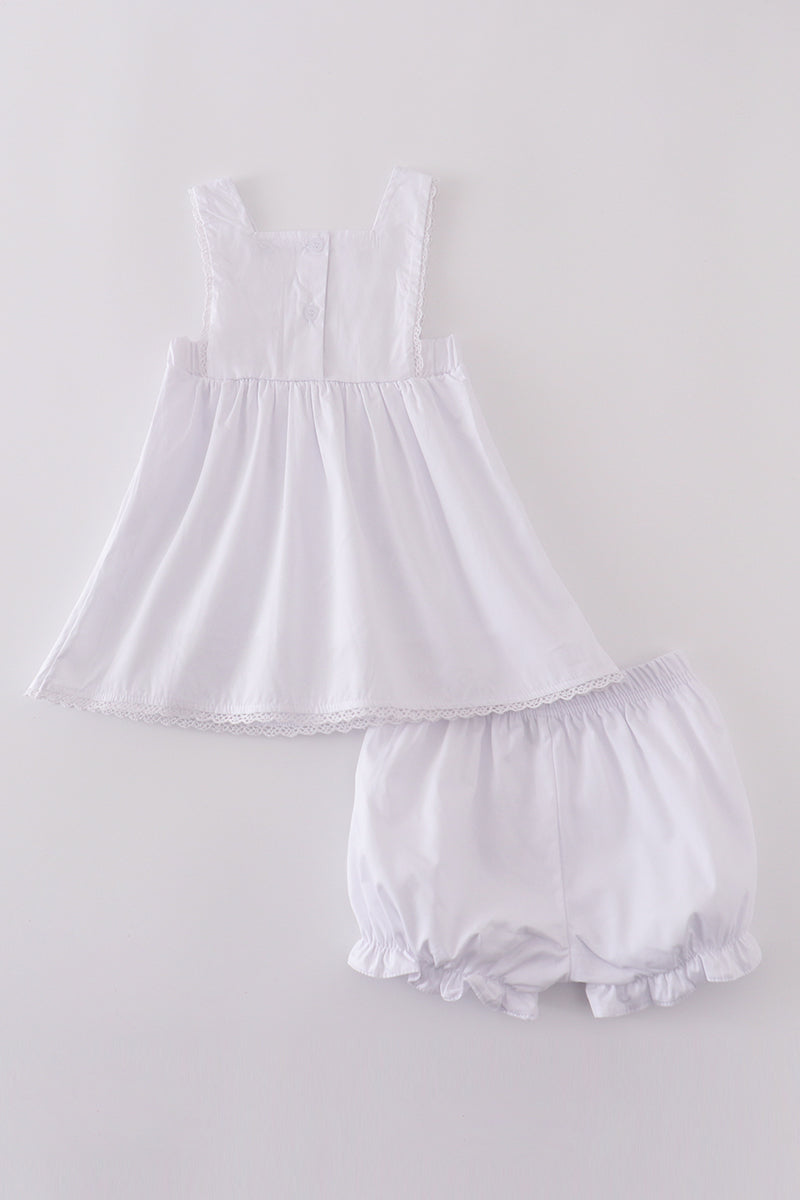 Soft, white romper with delicate cross embroidery, perfect for cozy playtime.