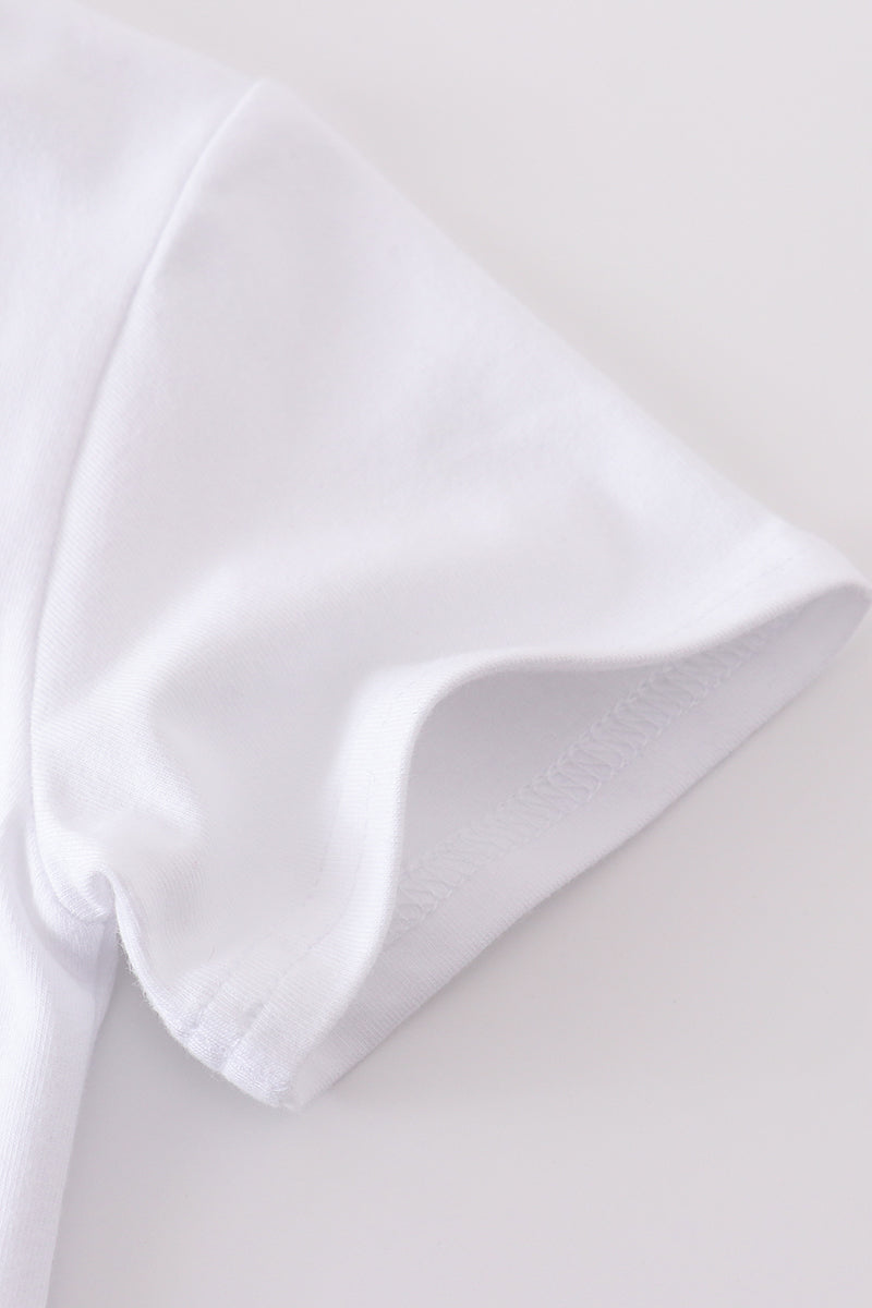 A cozy, white top with charming cross embroidery, perfect for playful adventures.