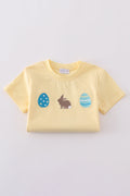 Warm mustard-colored children's top featuring a cute bunny and egg embroidery.