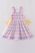 A charming pink plaid dress with bunny bow accents, perfect for springtime fun.