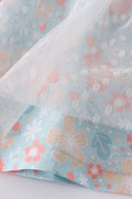 A charming green floral dress with bunny bow, perfect for springtime adventures.