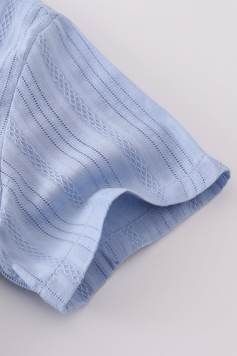A charming blue button-down shirt with cross embroidery, perfect for kids.