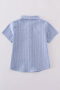 A charming blue button-down shirt with cross embroidery, perfect for kids.