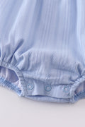 A cozy blue bubble romper with charming cross embroidery, perfect for playtime.
