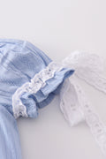 A cozy blue bubble romper with charming cross embroidery, perfect for playtime.