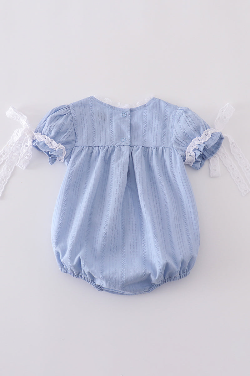A cozy blue bubble romper with charming cross embroidery, perfect for playtime.