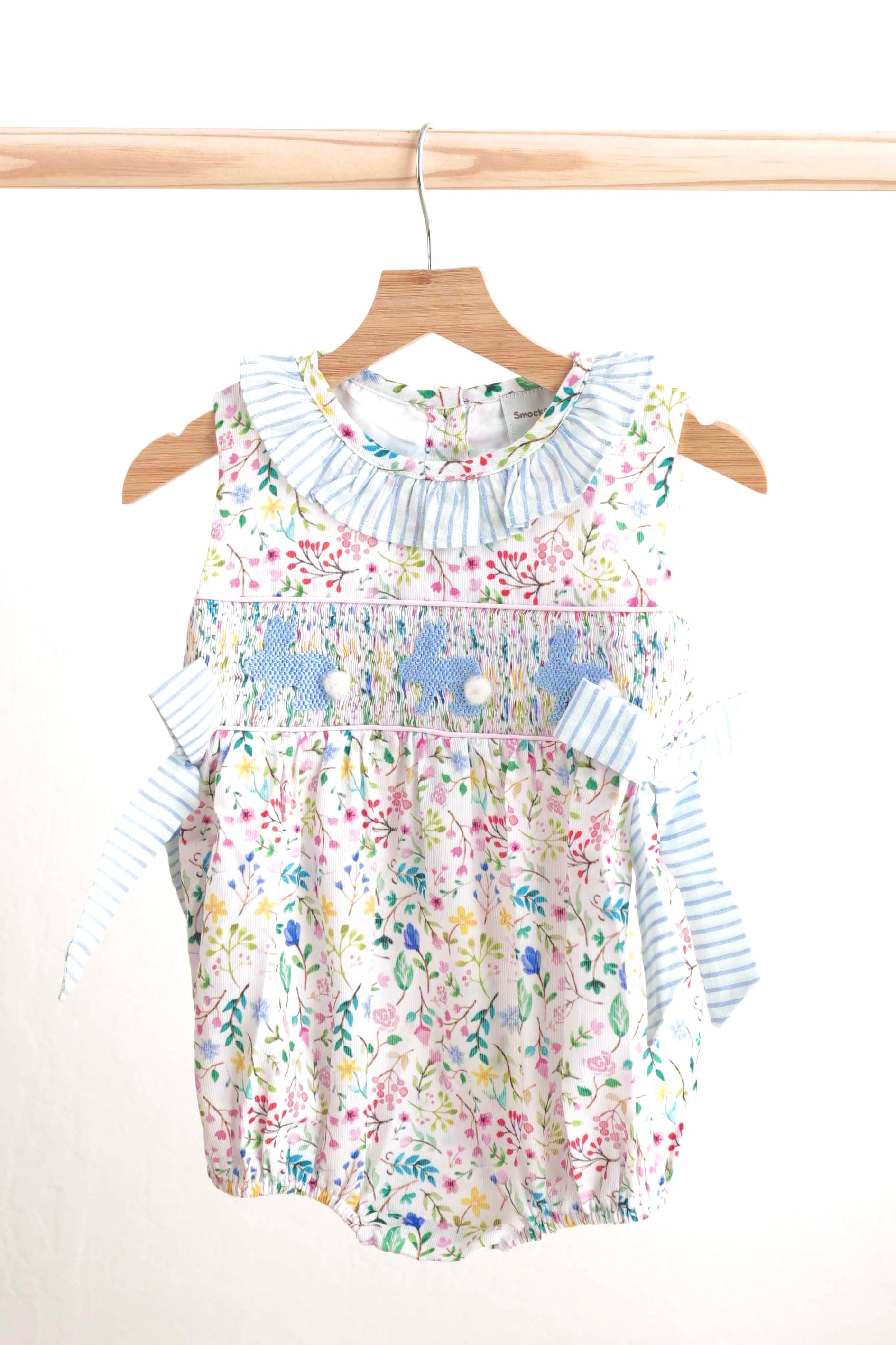 Floral Easter bunny hand-smocked girl bubble with pastel colors and ruffled sleeves.