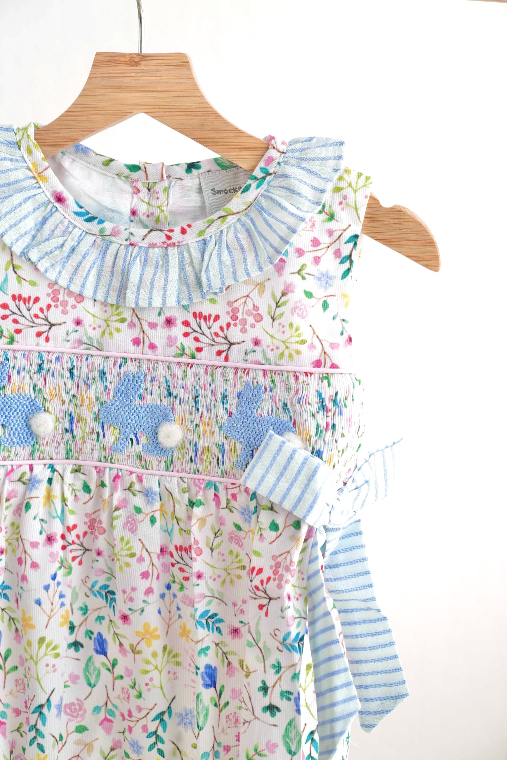 Floral Easter bunny hand-smocked girl bubble with pastel colors and ruffled sleeves.