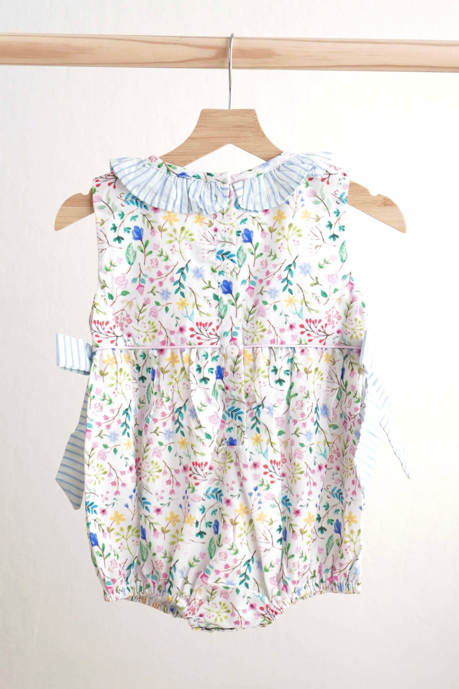 Floral Easter bunny hand-smocked girl bubble with pastel colors and ruffled sleeves.