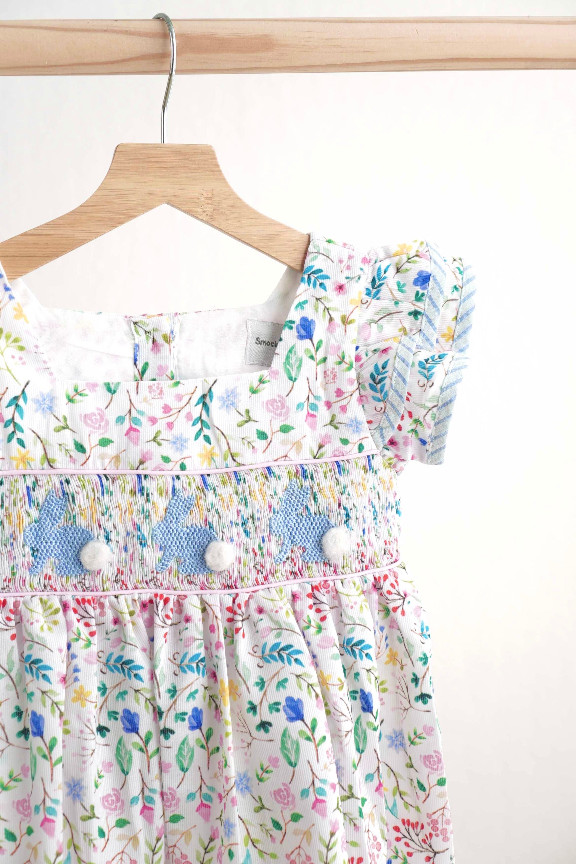 Floral Easter bunny hand-smocked dress with pastel colors and puffed sleeves.