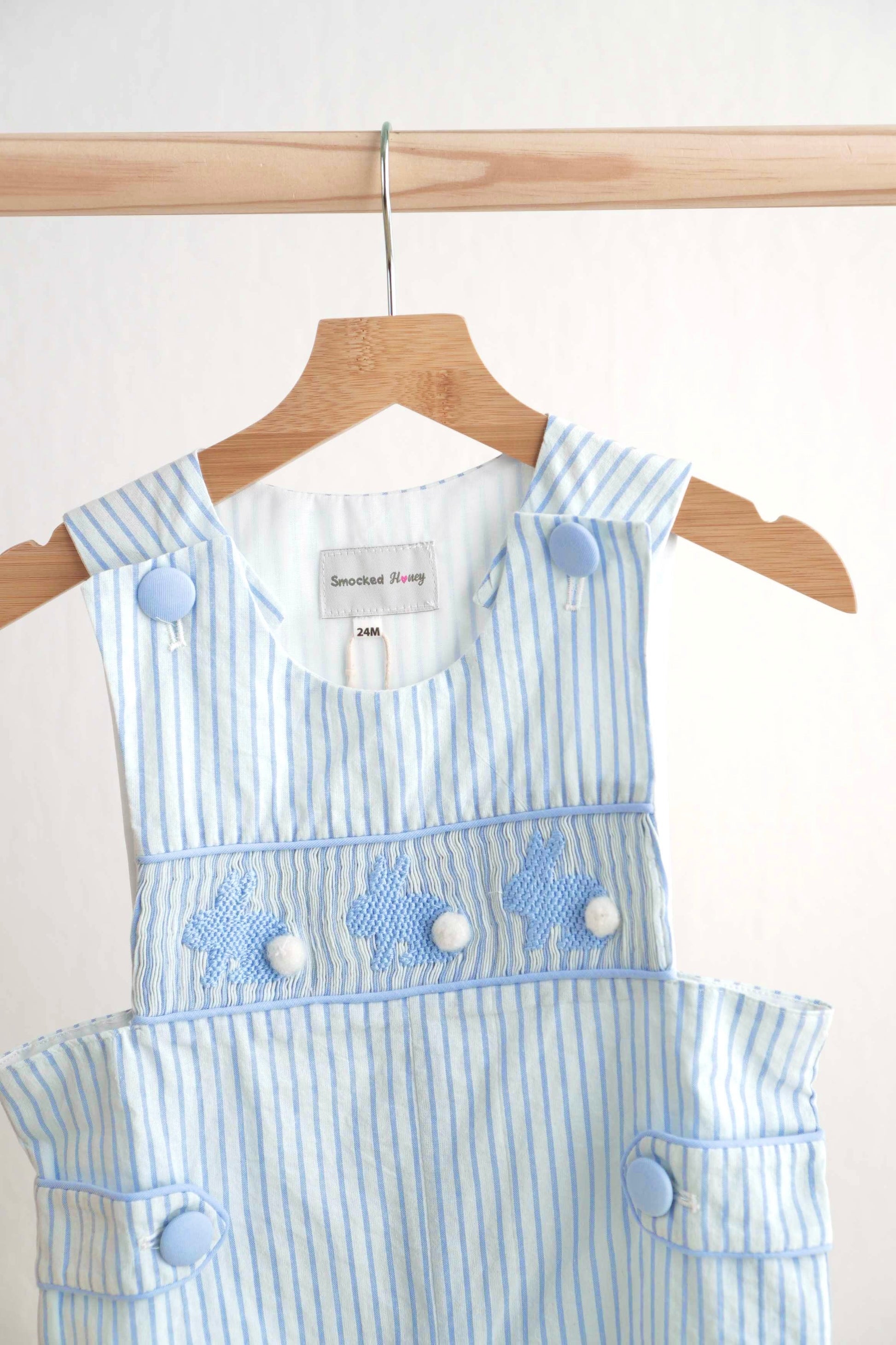 Blue Easter bunny hand-smocked jonjon with playful bunny pattern for boys.