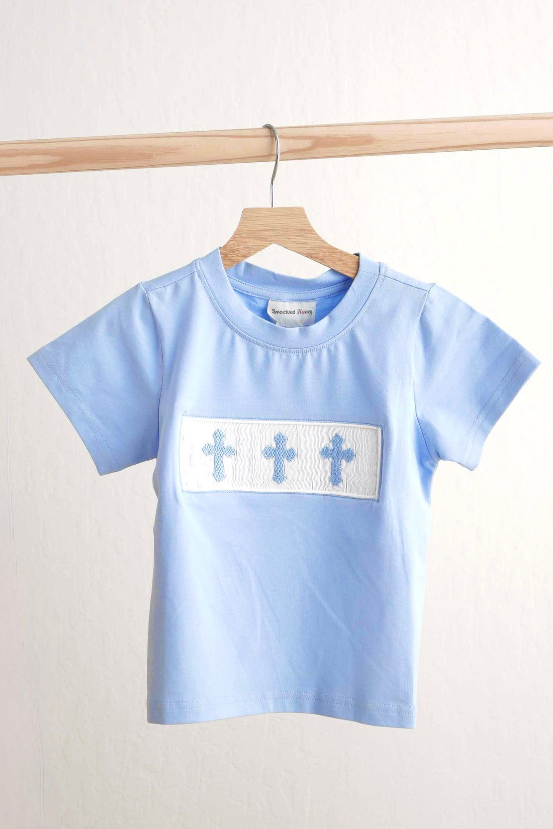 Blue Easter cross hand-smocked boy top with short sleeves and playful design.