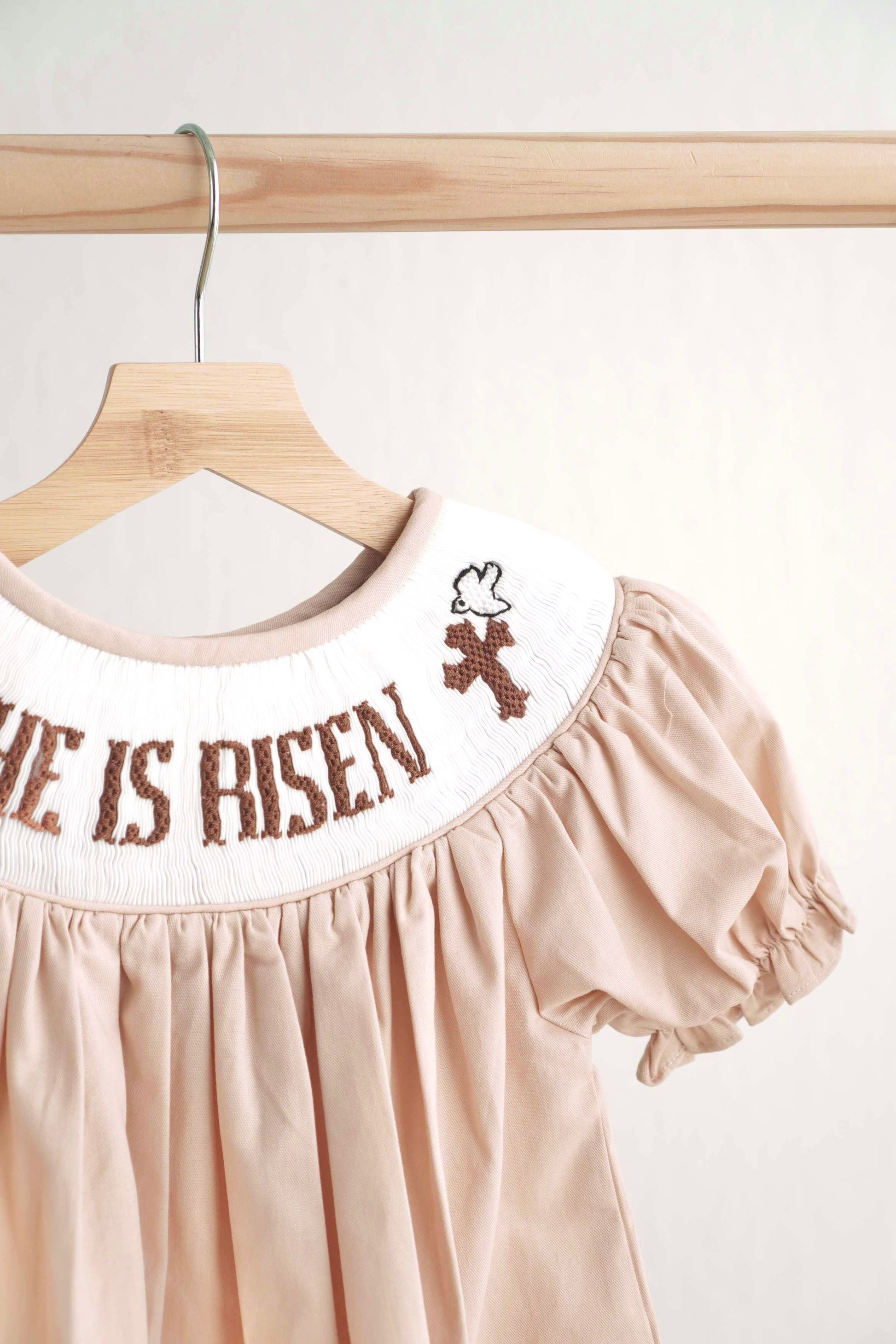 Khaki hand-smocked dress with "He is Risen" embroidery, perfect for Easter.