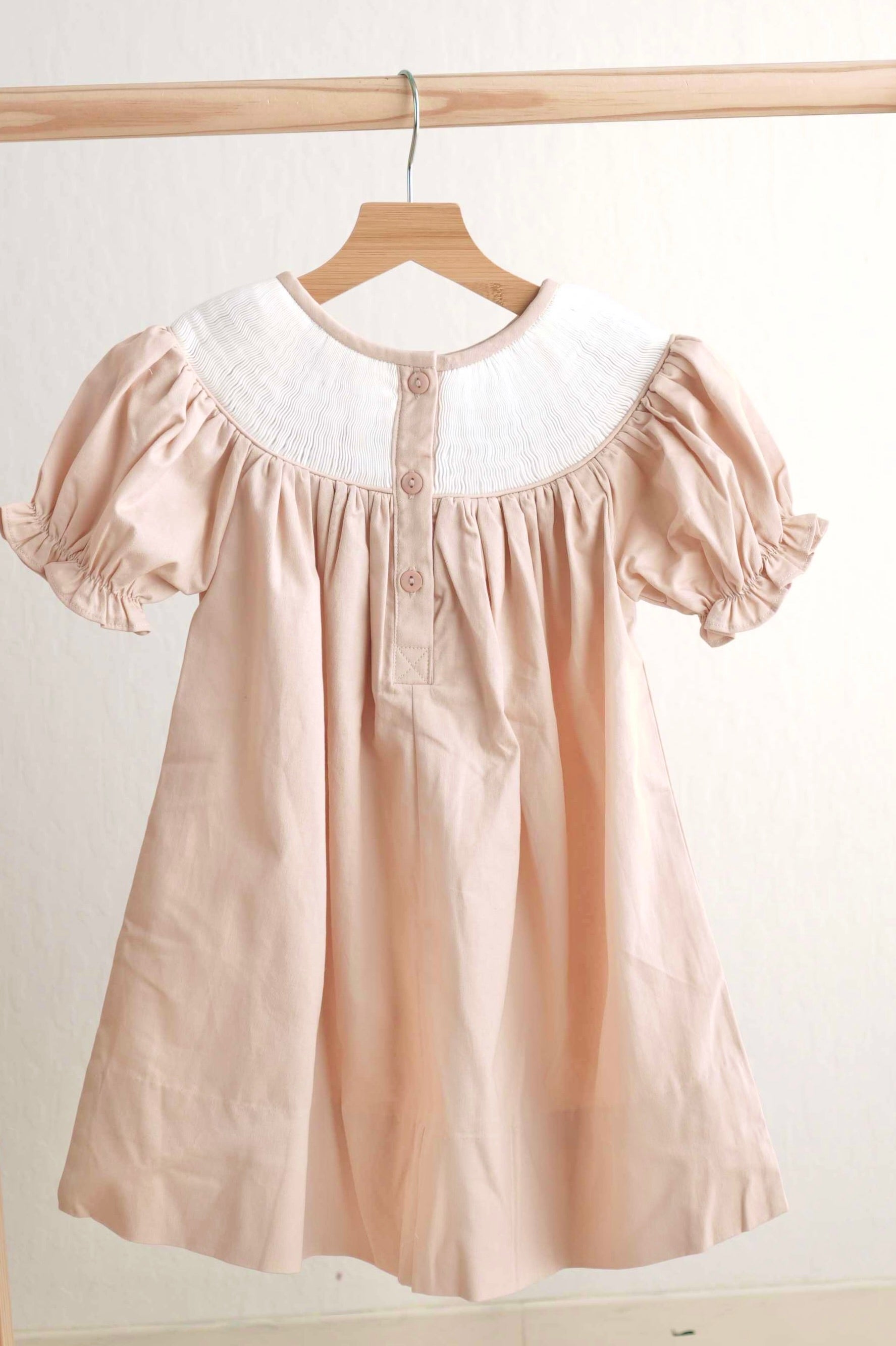 Khaki hand-smocked dress with "He is Risen" embroidery, perfect for Easter.