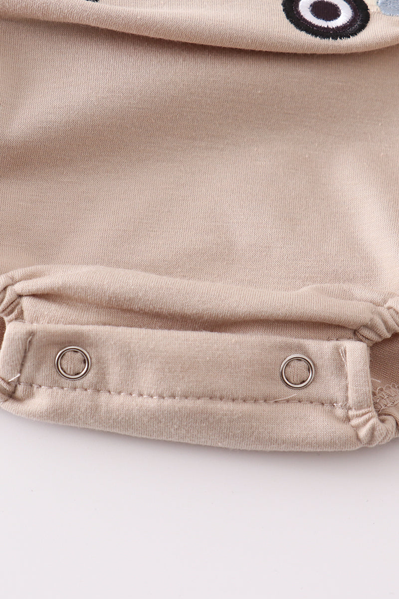 Khaki bubble romper with a cheerful truck applique, perfect for playtime.