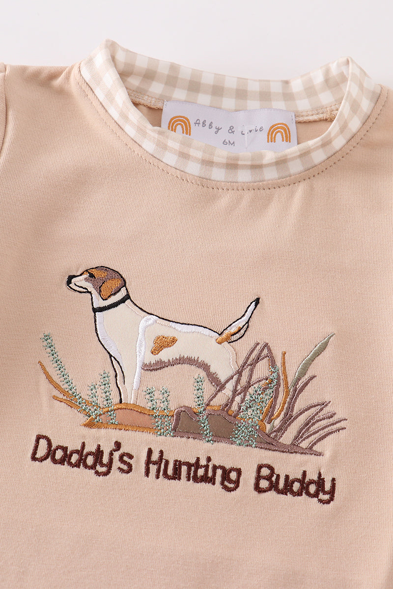 A cozy, blue romper with "Daddy's Hunting Buddy" embroidered in playful font.