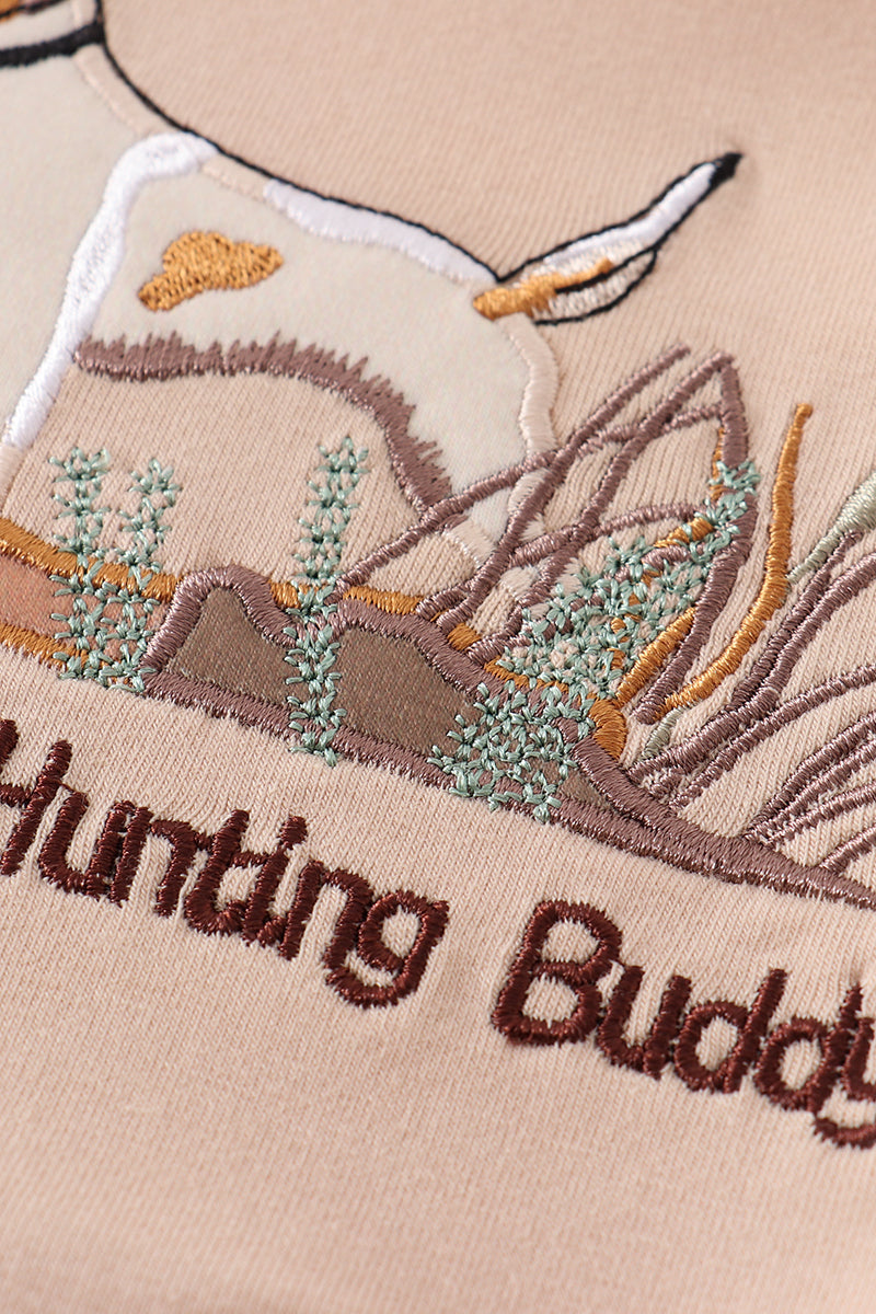 A cozy, blue romper with "Daddy's Hunting Buddy" embroidered in playful font.