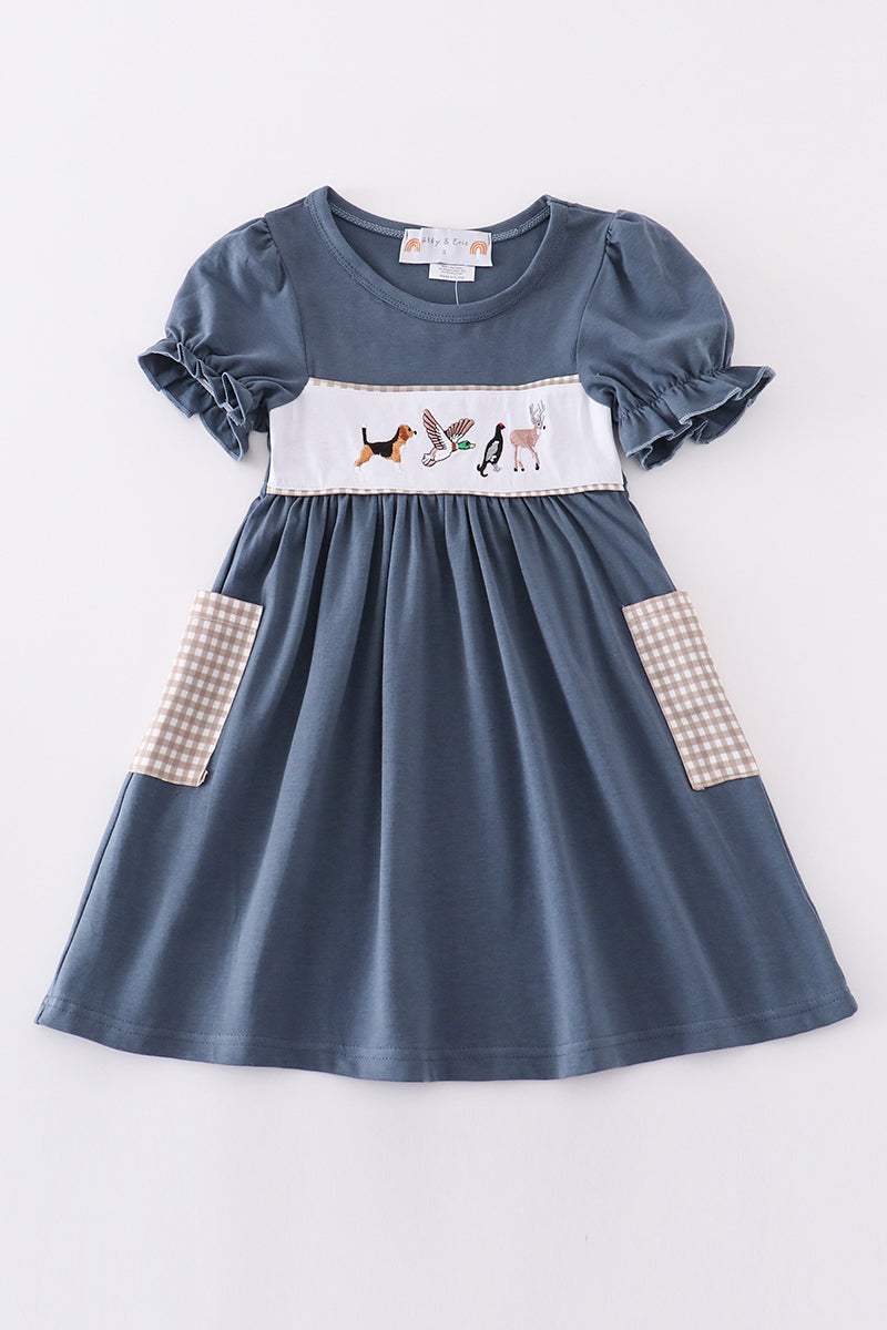 Navy dress with playful hunting embroidery, perfect for adventurous little ones.