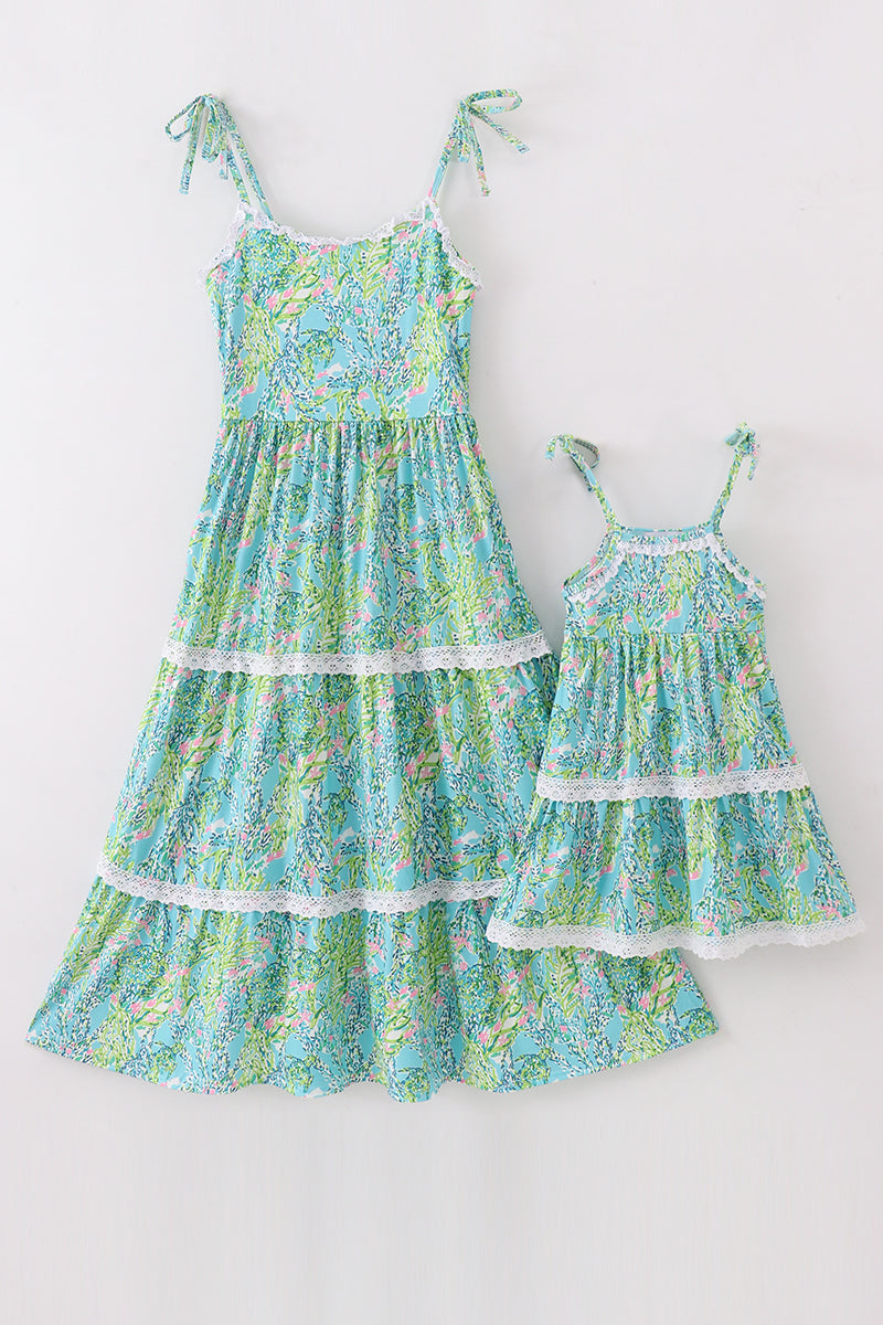 A charming green tiered dress with a floral pattern, perfect for matching mom and daughter.