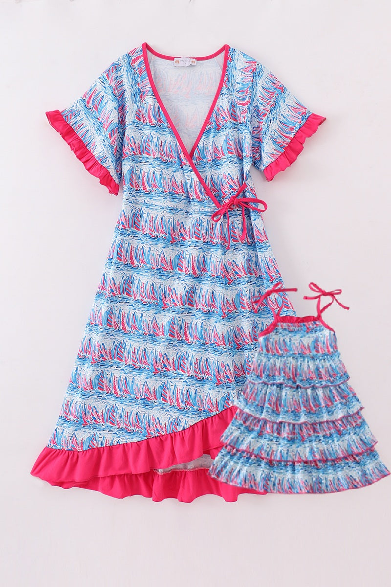 Matching mom and me dresses with playful blue sailboat print, perfect for summer outings.