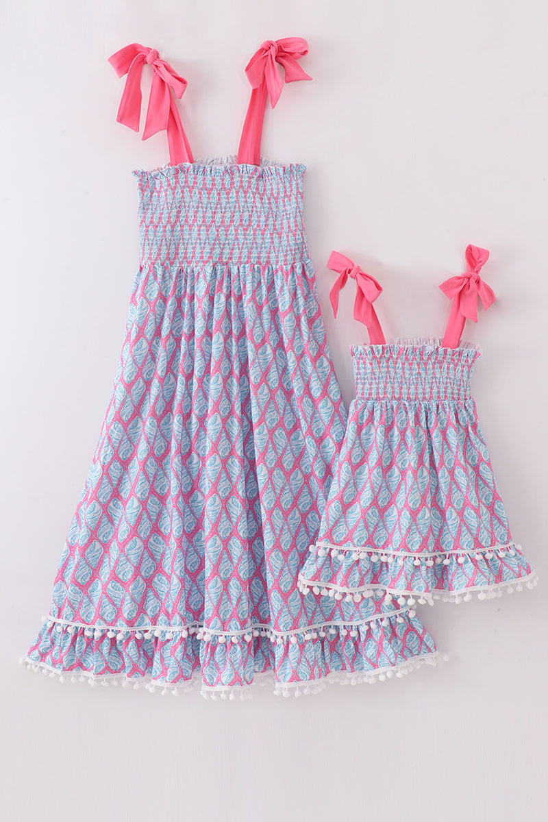 Matching blue smocked dresses with ribbon lace detailing for mom and daughter.