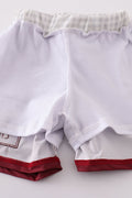 Maroon swim trunks with playful elephant embroidery, perfect for beach fun.