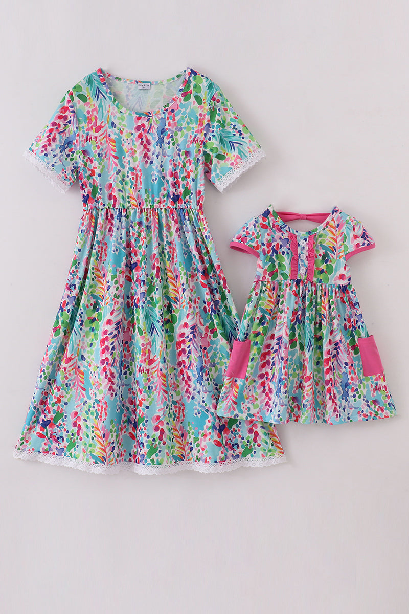 A vibrant Rainbow Garden print mom-and-me dress with playful floral patterns.