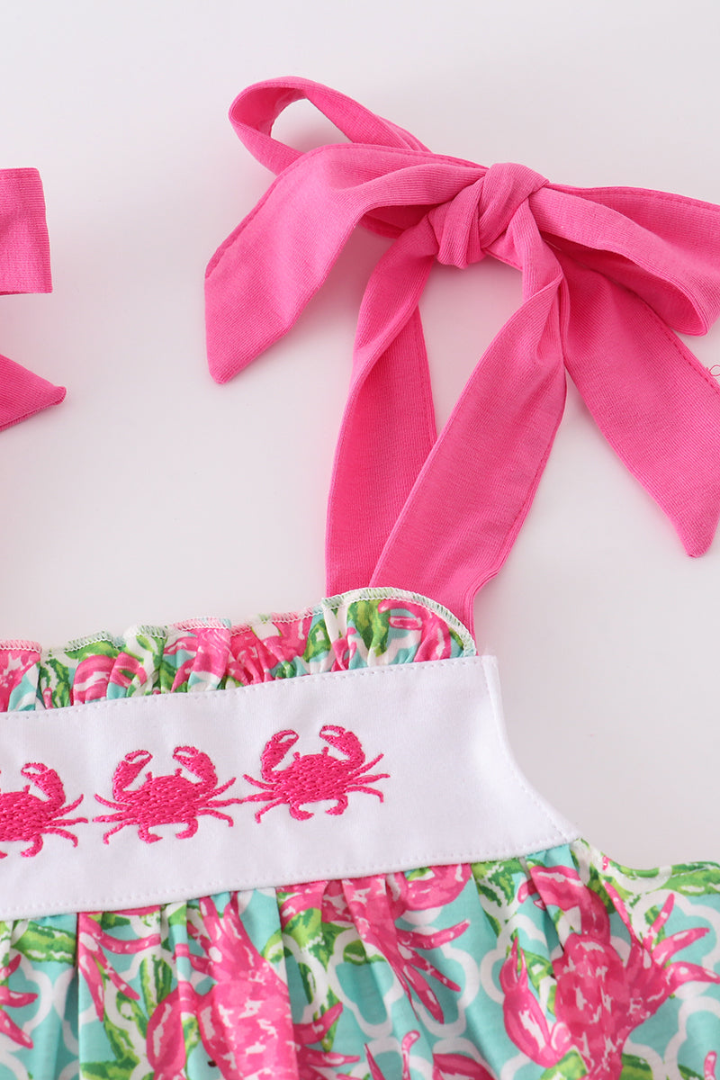 A charming pink dress with playful crab embroidery, perfect for summer fun.