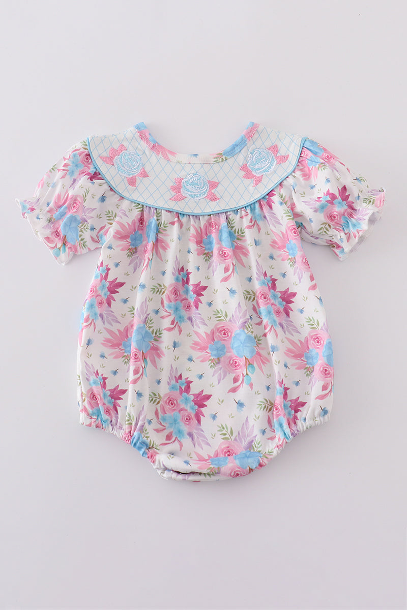 Whimsical blue bubble romper with floral embroidery, perfect for playful adventures.
