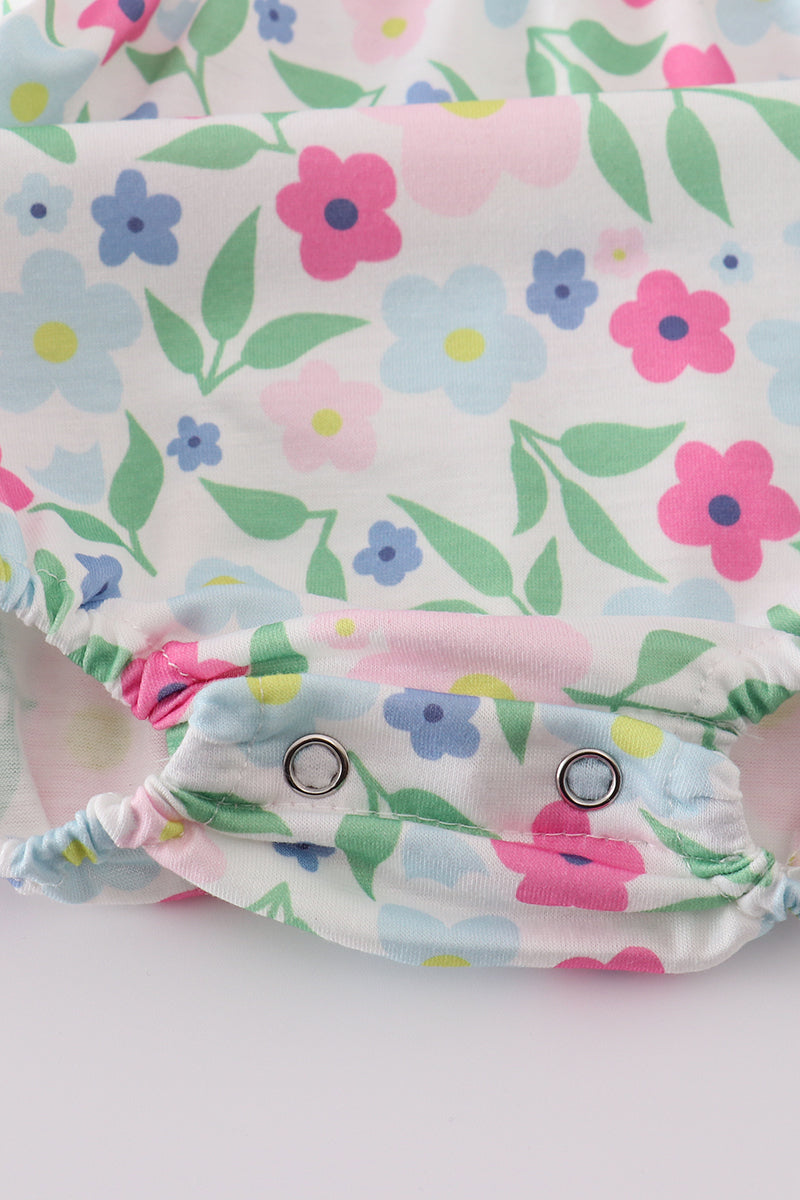Adorable girl bubble romper with vibrant meadow print, perfect for playful adventures.
