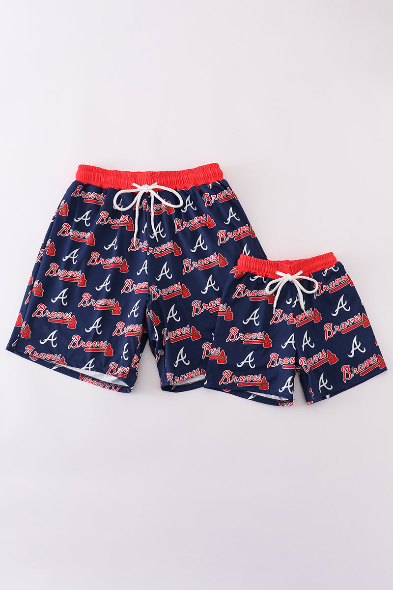 Matching navy swim trunks with Atlanta Braves logo for dad and son.