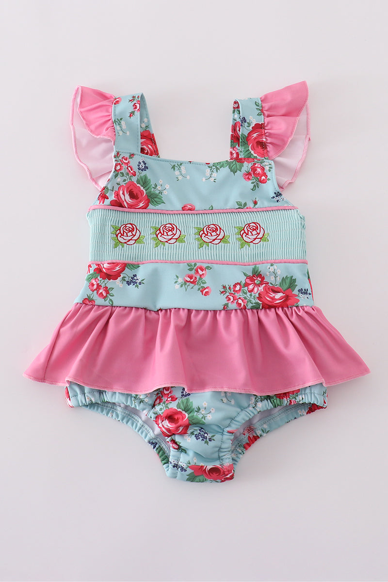 Colorful floral-print one-piece swimsuit with smocked details for girls.