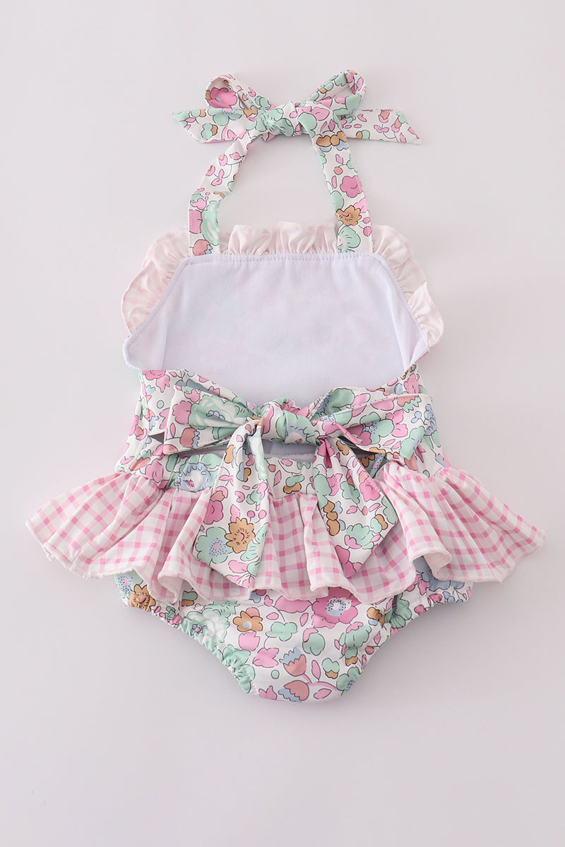 Pink floral one-piece swimsuit for kids, featuring cheerful flower patterns.