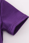 Toddler in a purple and gold LSU bloomer set with ruffled sleeves.