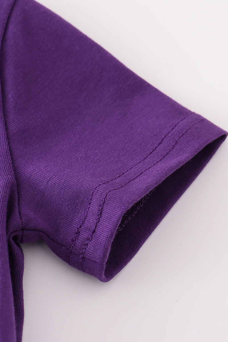 Toddler in a purple and gold LSU bloomer set with ruffled sleeves.