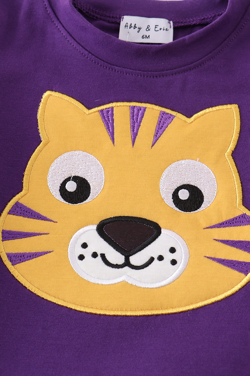 Toddler in a purple and gold LSU bloomer set with ruffled sleeves.