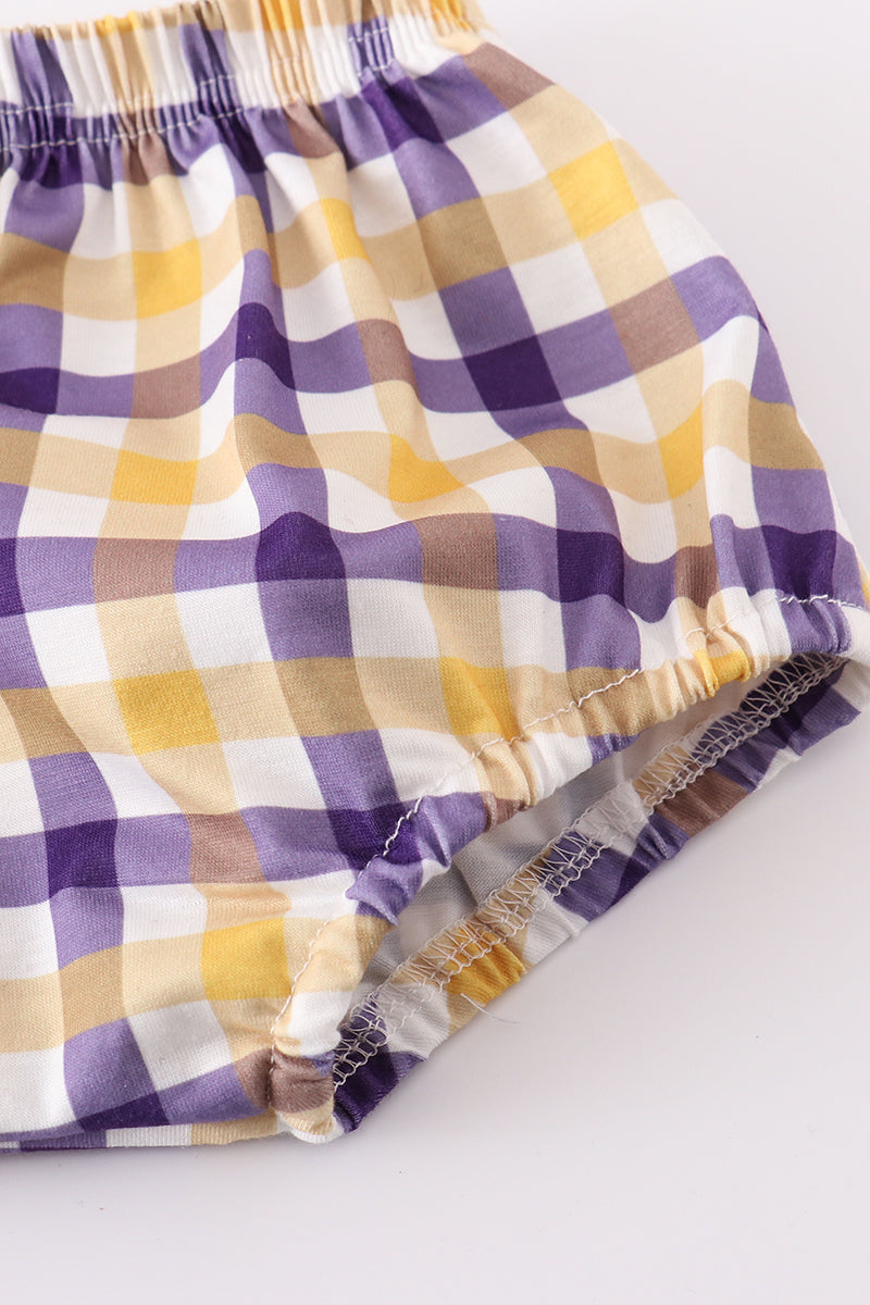 Toddler in a purple and gold LSU bloomer set with ruffled sleeves.
