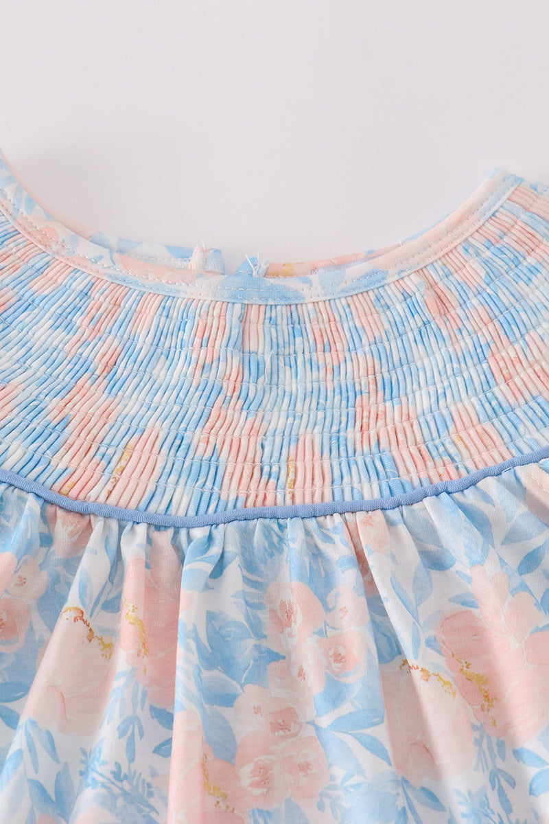 A charming blue smocked dress with floral ruffles, perfect for special occasions.