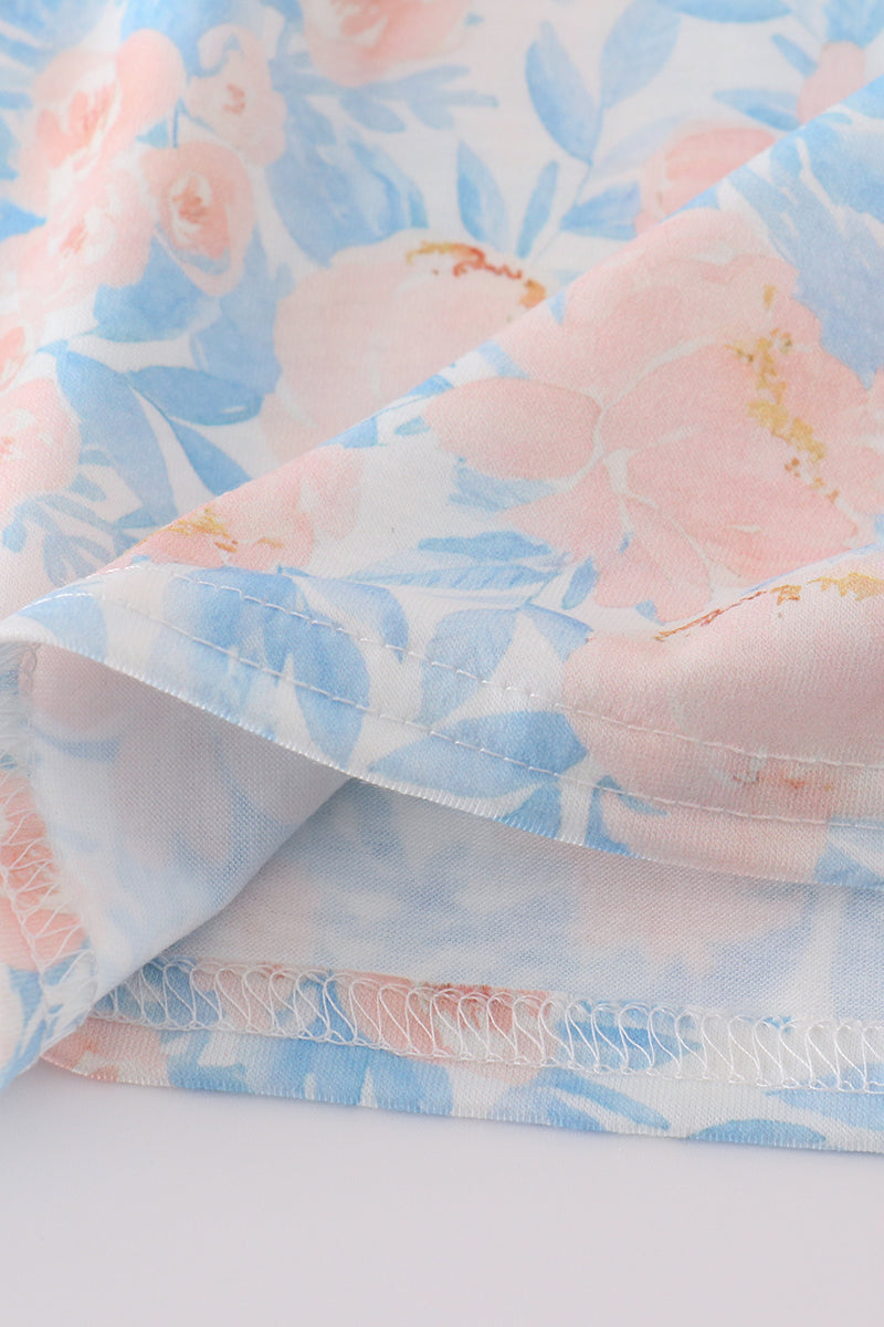A charming blue smocked dress with floral ruffles, perfect for special occasions.