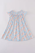 A charming blue smocked dress with floral ruffles, perfect for special occasions.