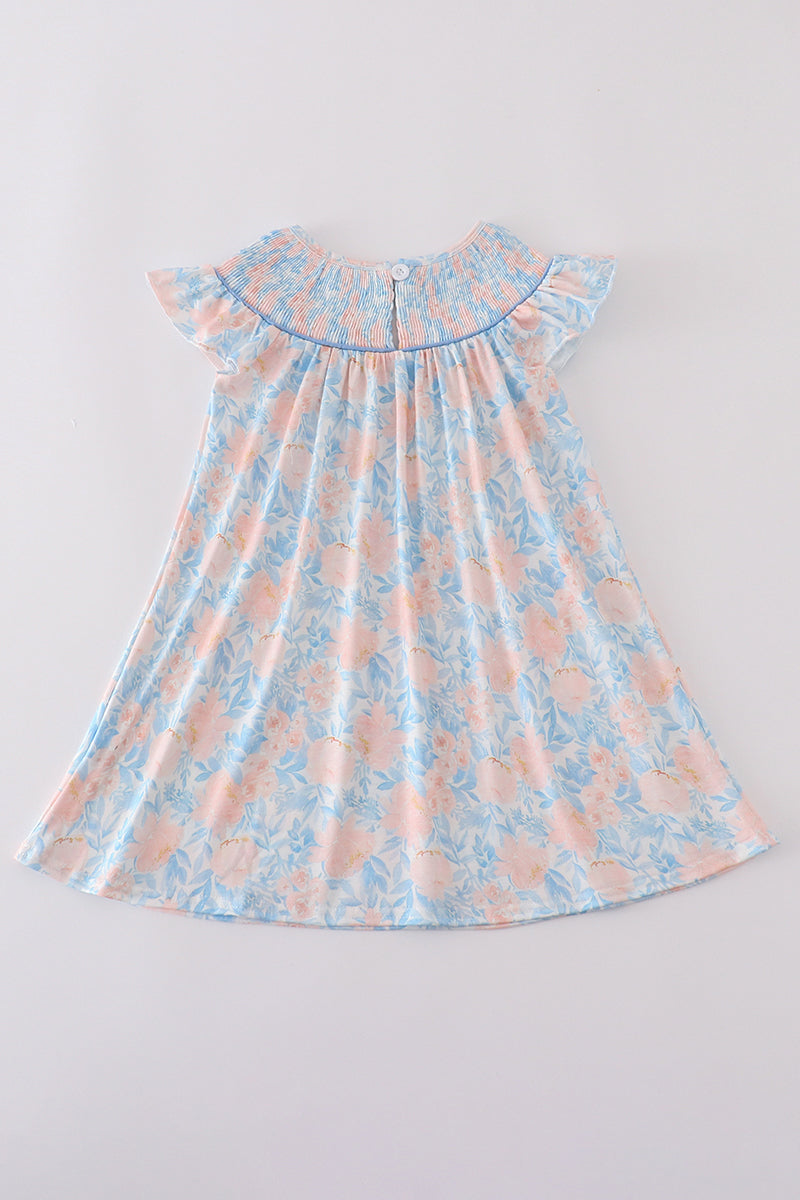 A charming blue smocked dress with floral ruffles, perfect for special occasions.