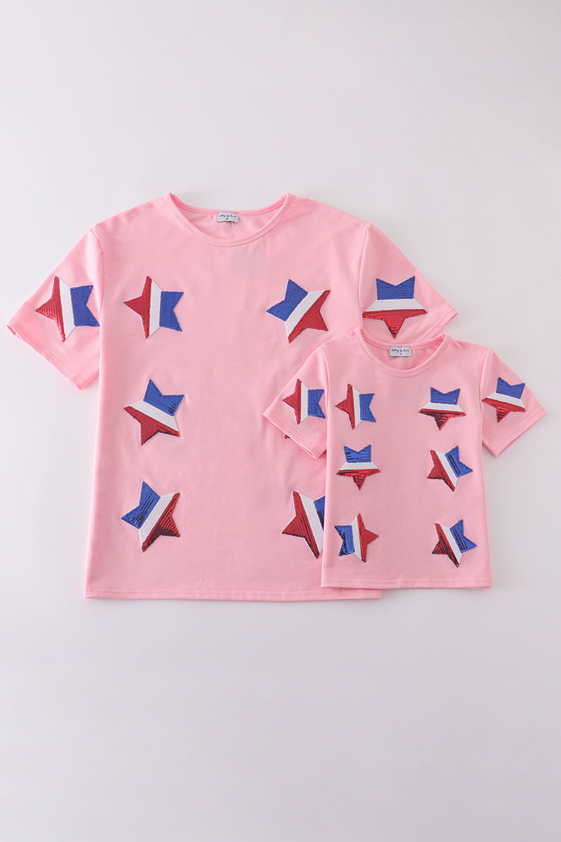 Matching pink tops adorned with shimmering star sequins, perfect for mother-daughter outings.