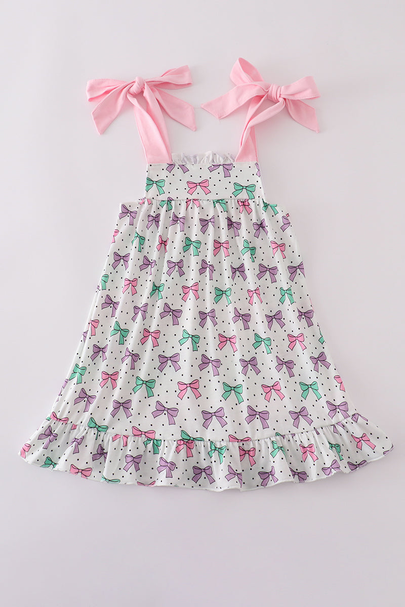 A charming pink dress with bow embroidery and playful ruffle details.