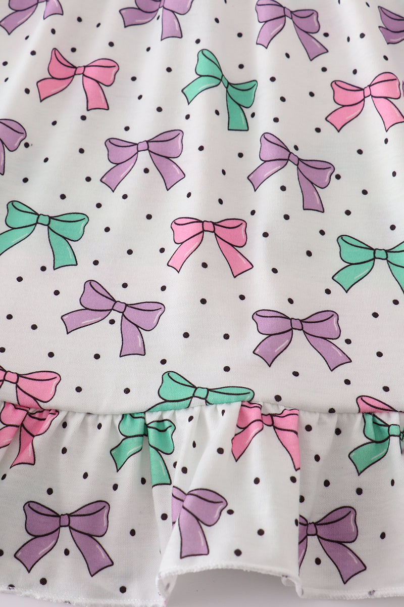 A charming pink dress with bow embroidery and playful ruffle details.