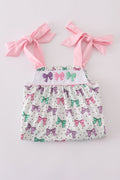 A charming pink dress with bow embroidery and playful ruffle details.