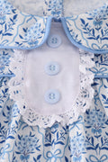 A charming blue toile garden bow dress with a playful floral pattern.