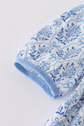A charming blue toile garden bow dress with a playful floral pattern.